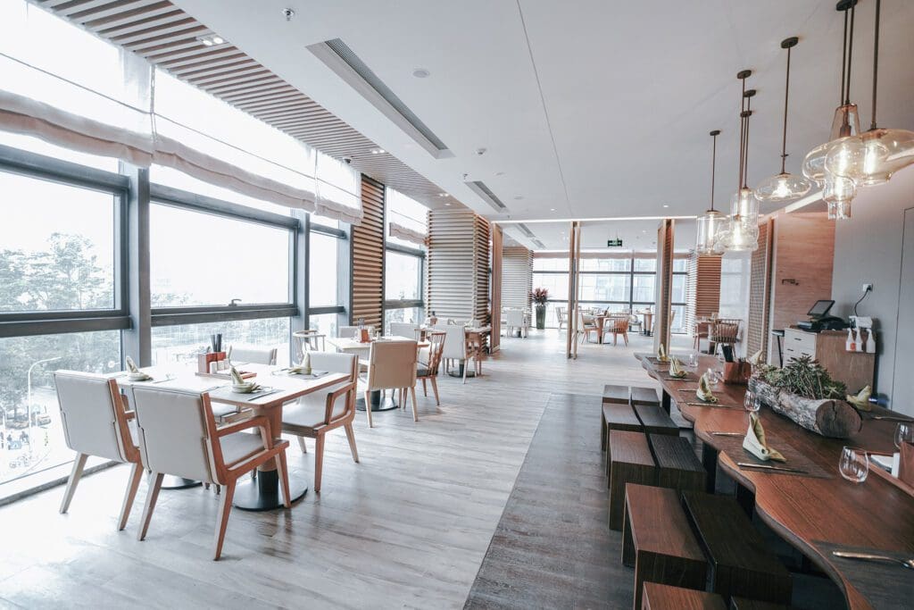Modern restaurant interior with wooden accents and large windows.