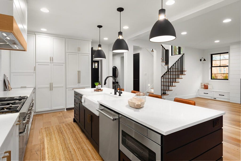 Modern kitchen with island, pendant lights, and wooden accents.