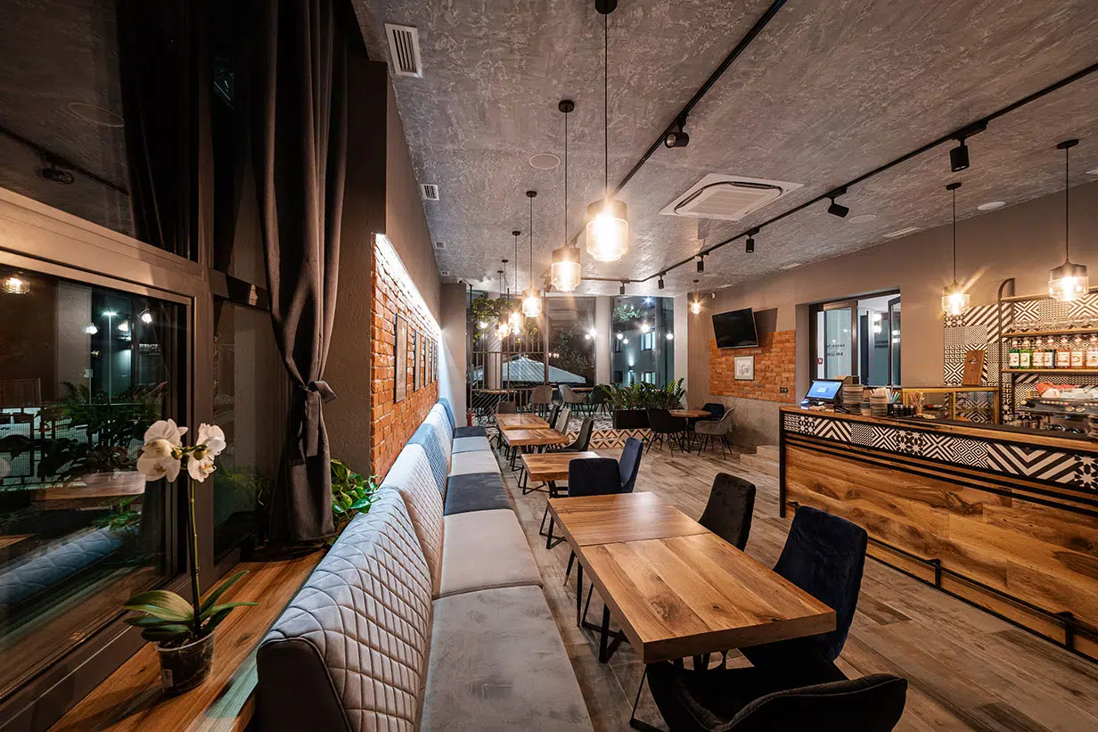 Modern cafe interior with wooden tables and ambient lighting.