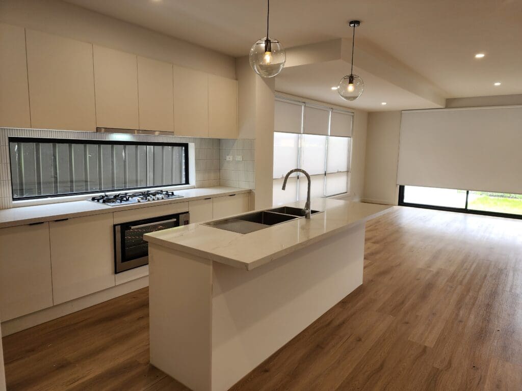 Modern kitchen featuring an island, sleek cabinetry, and large windows.